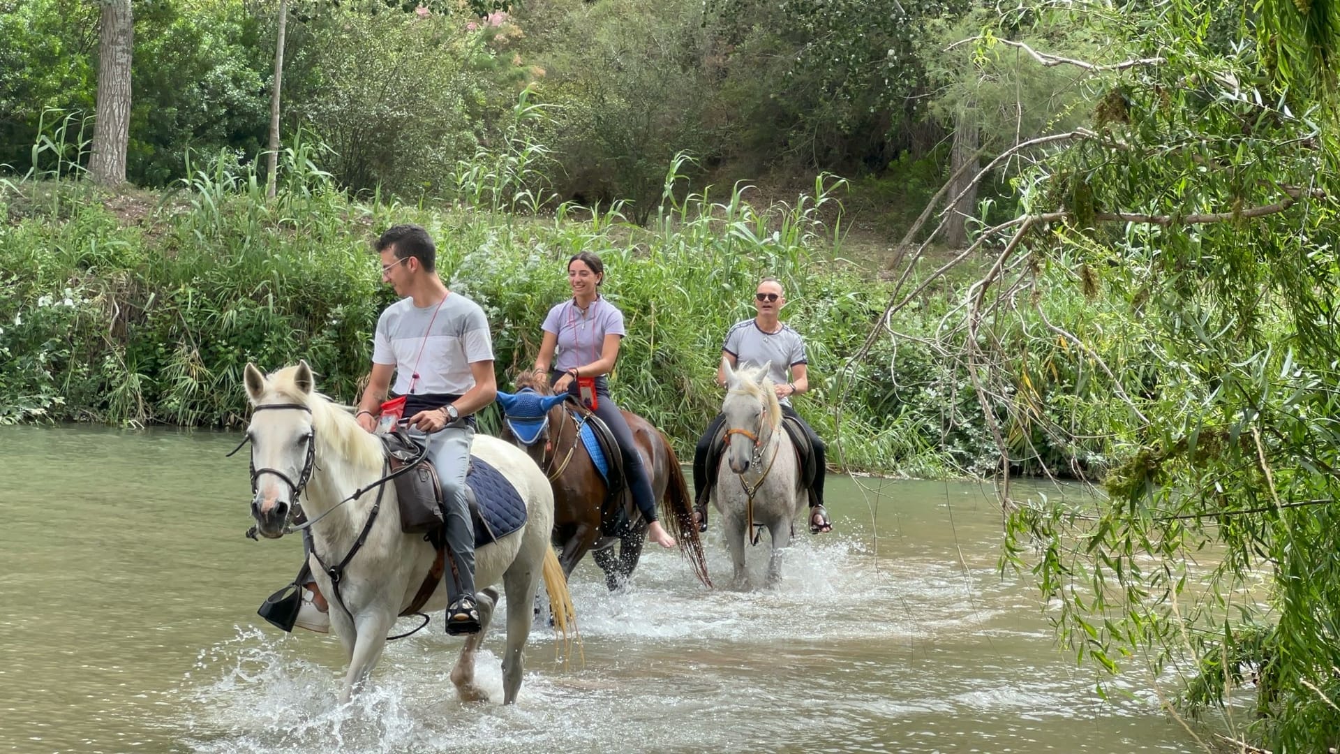 Jinetes cruzando el río a caballo durante una ruta por el Parque Natural de la Vallesa en Valencia